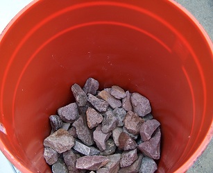 Rocks at the bottom of the bucket aid in drainage, and hold the furnace filter screen in place